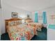 Comfortable bedroom with two beds featuring floral print bedding, framed artwork, and a window at 18610 Gulf Blvd # 208, Indian Shores, FL 33785