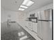 Well-lit kitchen boasts stainless steel refrigerator, white cabinets, and a granite countertop with a sink at 18610 Gulf Blvd # 208, Indian Shores, FL 33785
