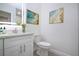 Bright bathroom showcasing a vanity, toilet, decorative art, and illuminated mirror at 1906 Canterbury Ln # 20, Sun City Center, FL 33573