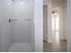 Modern shower with gray tile and sleek fixtures, leading to an open view of the living space at 1906 Canterbury Ln # 20, Sun City Center, FL 33573