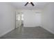 A clean bedroom features gray tile flooring, a ceiling fan, and a closet for a modern and comfortable living space at 1906 Canterbury Ln # 20, Sun City Center, FL 33573