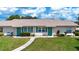 Charming attached villa featuring a well-maintained lawn, walkway and a turquoise front door at 1906 Canterbury Ln # 20, Sun City Center, FL 33573