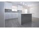 Bright kitchen features white cabinets, subway tile backsplash, stainless steel appliances, and an island at 1906 Canterbury Ln # 20, Sun City Center, FL 33573