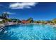 Sparkling community pool with lounge chairs, shaded umbrellas, and clear blue water on a sunny day at 1906 Canterbury Ln # 20, Sun City Center, FL 33573