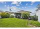 Lush backyard featuring a vibrant green lawn, manicured garden beds, and a white fence in a well-maintained landscape at 19409 Weymouth Dr, Land O Lakes, FL 34638