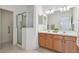 Bathroom with double sink vanity, tiled flooring, and glass door shower at 19409 Weymouth Dr, Land O Lakes, FL 34638