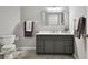 A full bathroom offers a gray vanity with a white countertop, complemented by a stylish framed mirror and neutral paint at 19409 Weymouth Dr, Land O Lakes, FL 34638
