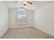 Cozy bedroom with vaulted ceiling, ceiling fan, and large window with plantation shutters at 19409 Weymouth Dr, Land O Lakes, FL 34638