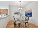 Dining area with wood floors, modern light fixture, and glass table at 19409 Weymouth Dr, Land O Lakes, FL 34638