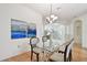 Bright dining room with wood floors, modern light fixture, and arched doorway at 19409 Weymouth Dr, Land O Lakes, FL 34638