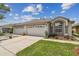 Lovely home with three-car garage and manicured lawn, showcasing curb appeal at 19409 Weymouth Dr, Land O Lakes, FL 34638