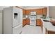Well-lit kitchen with a white refrigerator, gas range, microwave, and wooden cabinets at 19409 Weymouth Dr, Land O Lakes, FL 34638