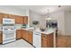 Bright kitchen features wooden cabinets, and a breakfast bar overlooking the adjacent dining area at 19409 Weymouth Dr, Land O Lakes, FL 34638