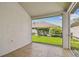 Enclosed patio with tiled floor and a view of the well-maintained backyard, green grass and mature shrubbery at 19409 Weymouth Dr, Land O Lakes, FL 34638