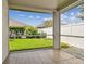 Screened-in lanai with tiled flooring, offering a view of the backyard, landscaping, and a partial privacy fence at 19409 Weymouth Dr, Land O Lakes, FL 34638