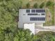 Aerial view of a modern house with solar panels surrounded by lush greenery at 2018 Windsor Way, Tampa, FL 33619
