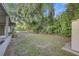 Spacious backyard with green grass and mature trees, offering plenty of privacy at 2018 Windsor Way, Tampa, FL 33619