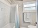 Bright bathroom featuring white tiling, a bathtub, and natural light at 2018 Windsor Way, Tampa, FL 33619