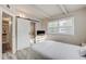 Bedroom featuring modern barn door to bathroom, wood floors and a sunlit window at 2018 Windsor Way, Tampa, FL 33619