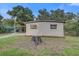 Exterior of home with large tree stump in the front yard and private drive and carport at 2018 Windsor Way, Tampa, FL 33619