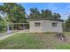 Home exterior with mature landscaping, a private drive, and a carport at 2018 Windsor Way, Tampa, FL 33619