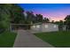 Charming single-story home with a cozy carport and well-maintained lawn at dusk at 2018 Windsor Way, Tampa, FL 33619