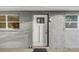 Inviting entryway with a white front door, textured wall, and stylish exterior light fixture at 2018 Windsor Way, Tampa, FL 33619