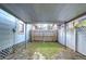 Backyard view of a covered patio with a partial lawn, privacy fence, and a view of surrounding houses at 205 W Emma St, Tampa, FL 33603