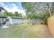 Backyard view of a fenced-in yard with a lawn, privacy fence, garden beds and a storage shed at 205 W Emma St, Tampa, FL 33603