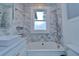 Bright bathroom featuring a white marble tiled wall and modern bathtub with a shower head and updated fixtures at 205 W Emma St, Tampa, FL 33603