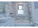Bright bathroom featuring a white marble tiled wall and modern bathtub with a shower head and updated fixtures at 205 W Emma St, Tampa, FL 33603