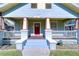 Detailed view of the home's charming porch, showcasing its pillars, railings, and the red front door at 205 W Emma St, Tampa, FL 33603