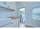 Cozy kitchen featuring white cabinets, tile floors, butcher block countertop, and a view of the backyard through a door at 205 W Emma St, Tampa, FL 33603