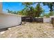 Spacious backyard showcasing the home's exterior, screened lanai, lush trees, and fenced perimeter at 2066 62Nd Pl S 62Nd Pl, St Petersburg, FL 33712