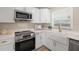 This is a lovely kitchen with modern appliances, bright cabinets, and a farmhouse sink with gold fixtures at 2066 62Nd Pl S 62Nd Pl, St Petersburg, FL 33712