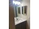 Bathroom with a gray vanity, white sink, and framed mirror with modern lighting at 2160 Corbin Pl # C, Palm Harbor, FL 34683