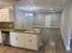 Open-concept kitchen and living room with modern lighting, granite countertops, and wood flooring at 2160 Corbin Pl # C, Palm Harbor, FL 34683