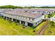 Aerial view of townhomes with green grass, palm trees, and landscaping at 2190 Great Sapphire Ln, Lutz, FL 33558