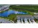 Aerial view of gray townhomes next to a lake with trees and grassy areas at 2190 Great Sapphire Ln, Lutz, FL 33558