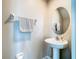 Half bathroom with a pedestal sink, oval mirror and neutral walls at 2190 Great Sapphire Ln, Lutz, FL 33558