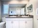 Bathroom with double sinks, granite countertop, a vanity, and a large mirror at 2190 Great Sapphire Ln, Lutz, FL 33558