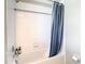 This bathroom features a shower and bathtub combo with white tiles and a blue shower curtain at 2190 Great Sapphire Ln, Lutz, FL 33558