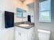 This bathroom has a granite countertop, white cabinets, a large mirror, and a neutral wall color at 2190 Great Sapphire Ln, Lutz, FL 33558