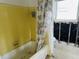 Vintage bathroom featuring yellow tile and a tub, ready for renovation and a modern upgrade at 2469 Trade Winds Dr, Dunedin, FL 34698