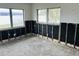 Bedroom space with exposed studs awaiting a renovation, boasting natural light from dual windows at 2469 Trade Winds Dr, Dunedin, FL 34698