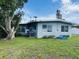 Exterior view of a single story home with light blue paint and a lawn at 2469 Trade Winds Dr, Dunedin, FL 34698