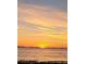 Beautiful sunset over the water with clouds in the sky and beach in the foreground at 2469 Trade Winds Dr, Dunedin, FL 34698