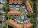 Aerial view of a residential community featuring red tile roofs, green landscaping, carports, and a community pool at 2640 Enterprise E Rd # B25, Clearwater, FL 33759