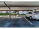 Carport with assigned parking and well-maintained landscaping and nearby stairs to the upper level homes at 2640 Enterprise E Rd # B25, Clearwater, FL 33759