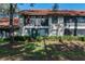 Two-story building featuring a red tile roof, manicured landscaping, and an inviting facade at 2640 Enterprise E Rd # B25, Clearwater, FL 33759
